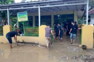 Anggota 234 SC saat membantu memberihakan rumah yang terkena banjir.