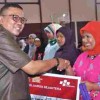 Plt Bupati saat menyerahkan bansos non tunai PKH.